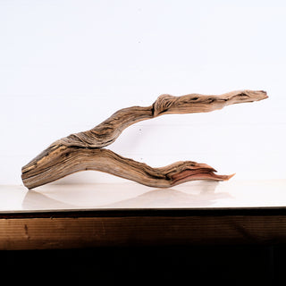 Manzanita Driftwood 35" piece displayed on a wooden surface with natural twisted texture and light background